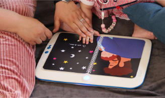 Photographie représentant un enfant d’environ 1 an et un parent en train d’utiliser un prototype de la console 