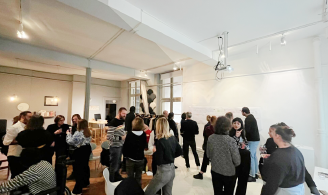 Photographie représentant une cinquantaine de personnes réunies lors d’un événement ; on distingue une cartographie accrochée au mur.