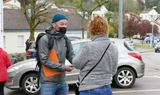 Photographie représentant un designer dans un espace public, en train d'échanger avec une habitante du quartier pour une enquête terrain.